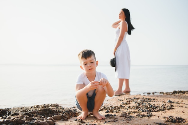 Moeder en zoon wandelen langs het strand