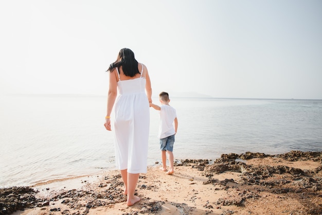 Moeder en zoon wandelen langs het strand