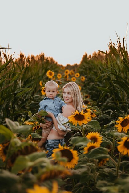 moeder en zoon zijn blij moeder en baby lachen zonnebloemveld de ondergaande zon