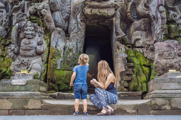 Moeder en zoon zijn toeristen in de oude hindoe-tempel van Goa Gajah in de buurt van Ubud op het eiland Bali, Indonesië. Reizen in Bali met kinderen concept