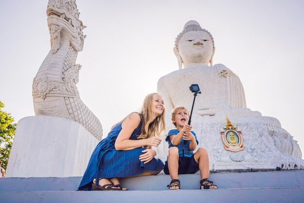 Moeder en zoonstoeristen op het grote boeddhabeeld. werd gebouwd op een hoge heuveltop van phuket thailand kan van een afstand worden gezien. reizen met kinderen concept.