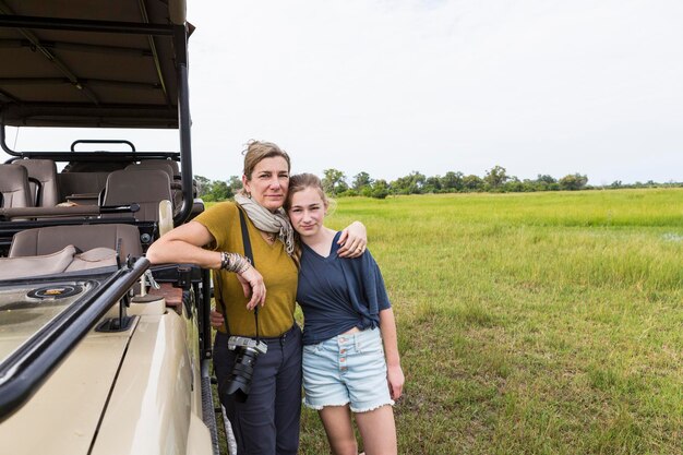 Moeder fotografeert met tienerdochter in de buurt van safarivoertuig Botswana