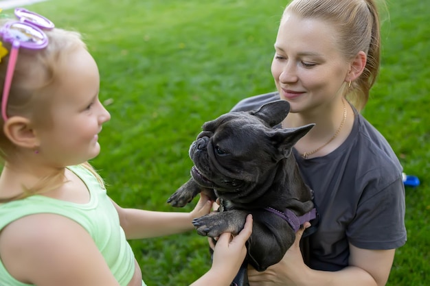 Moeder geeft de hond door aan haar dochtertje oni in het park