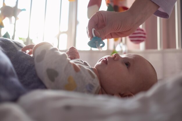 Moeder geeft haar kleine baby een fopspeen om haar te kalmeren