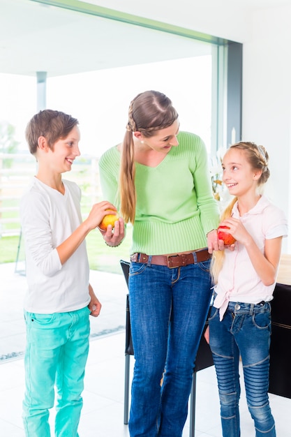 Moeder geeft kinderen appel voor gezond leven