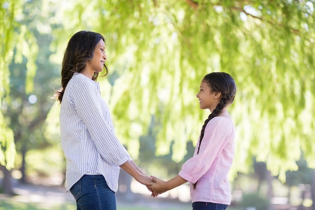 Moeder hand in hand van haar dochter in park