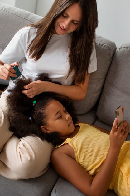 Foto moeder helpt haar kind afro-haar te stylen