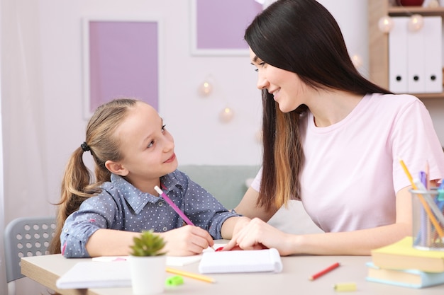 Moeder helpt het meisje om huiswerk te maken kinderen en ouders