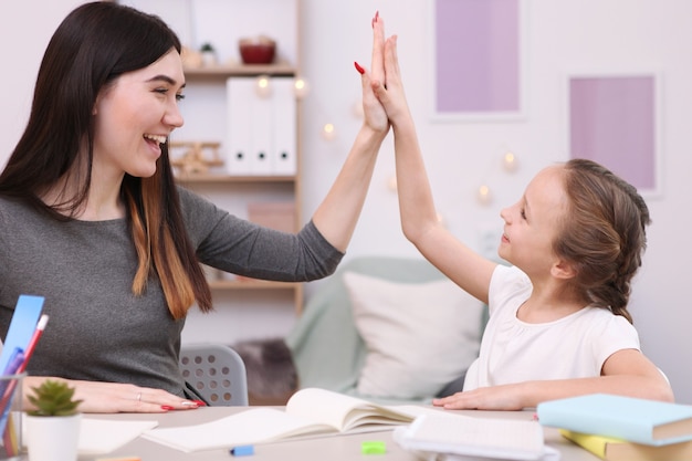 Moeder helpt het meisje om huiswerk te maken kinderen en ouders