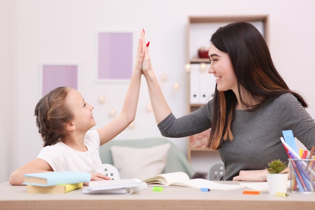 Moeder helpt het meisje om huiswerk te maken kinderen en ouders