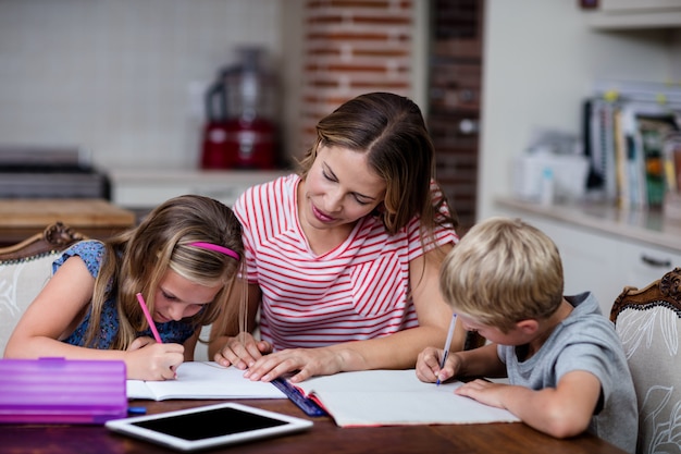 Moeder helpt kinderen met hun huiswerk