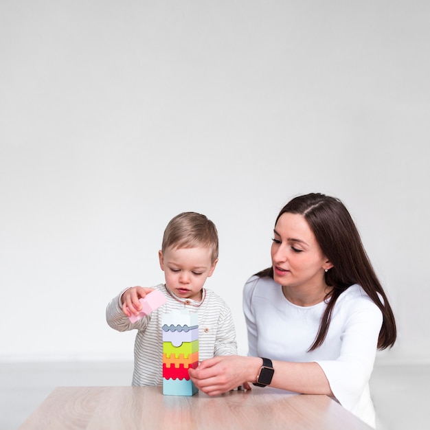 Foto moeder het spelen met baby thuis met exemplaarruimte