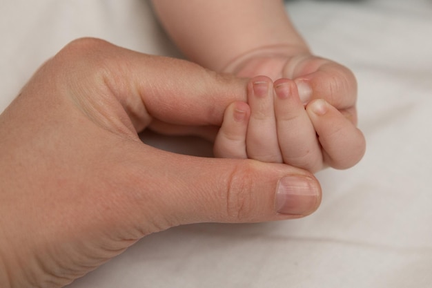 moeder houdt de baby bij de hand