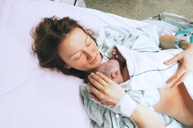 Moeder houdt haar pasgeboren baby vast na de bevalling in een ziekenhuis moeder bevalt van een jongetje