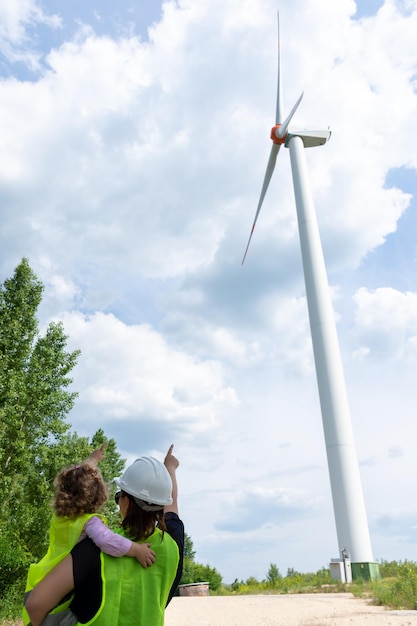 Moeder ingenieur met dochter die naar een windmolen kijkt