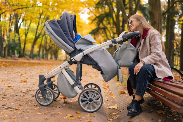 Moeder kijkt naar de baby die in de kinderwagen slaapt