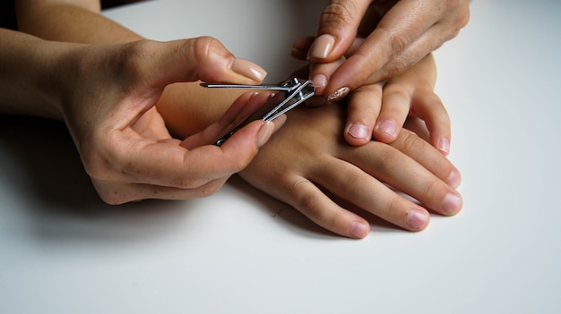 Foto moeder knipt de nagels van haar kind.