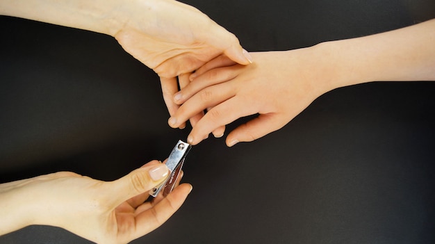 Foto moeder knipt haar kindernagels. close-up