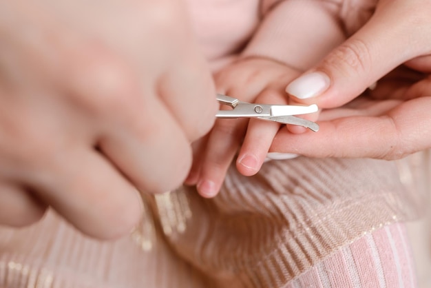 Moeder knipt nagels aan kleine baby