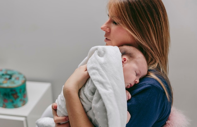 Moeder knuffelt haar slapende babymeisje