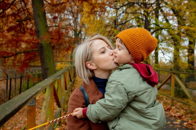 Moeder kust zoon in herfstpark