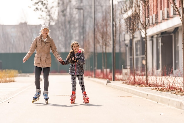 Foto moeder leert dochter rolschaatsen.