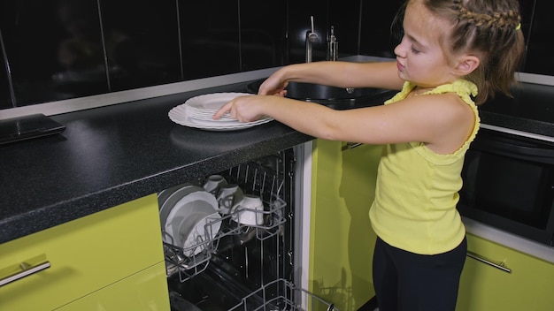 Moeder leert dochter slim meisje leren vaatwasser te gebruiken