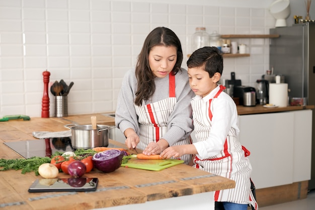 Moeder leert haar zoon hoe hij gezond voedsel kan koken in de keukenlevensstijl met latino-mensen in alleenstaande...