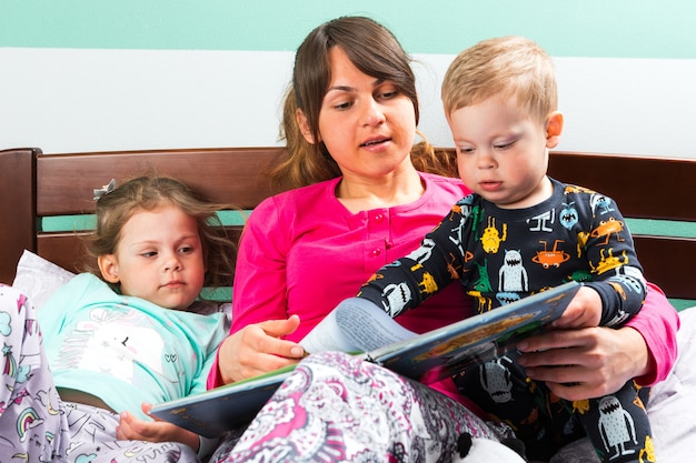 Foto moeder lezen verhaaltje voor het slapengaan aan kinderen