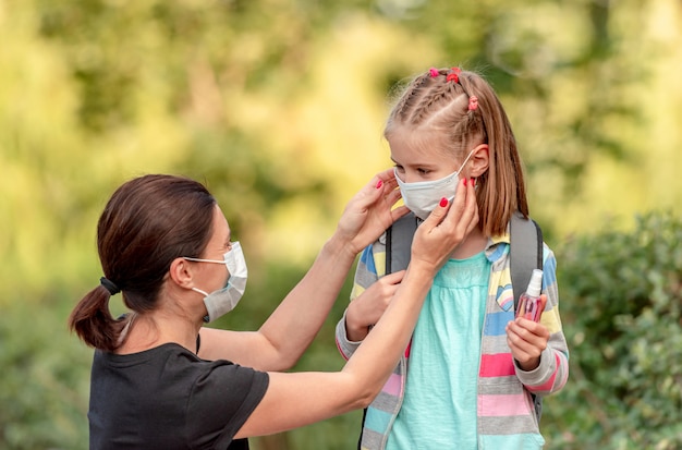 Moeder masker op dochter zetten voor school