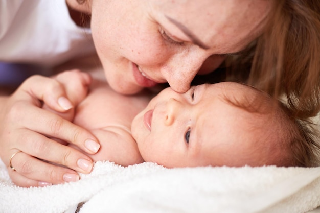 Moeder masseert haar pasgeboren babyjongen Realistisch huisportret