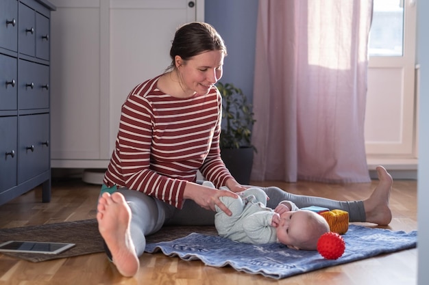 Moeder met baby maakt thuis yoga om sterk en gezond te zijn
