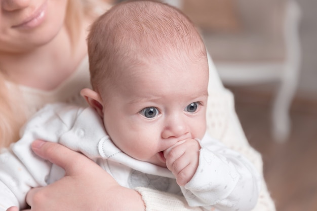 Moeder met baby zit bij de open haard in een gezellige woonkamer. foto met kopieerruimte