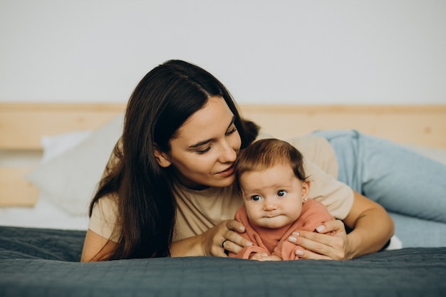 Moeder met babydochter die op bed ligt