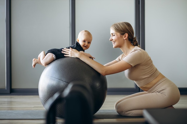 Moeder met babydochter die op yogabal zit