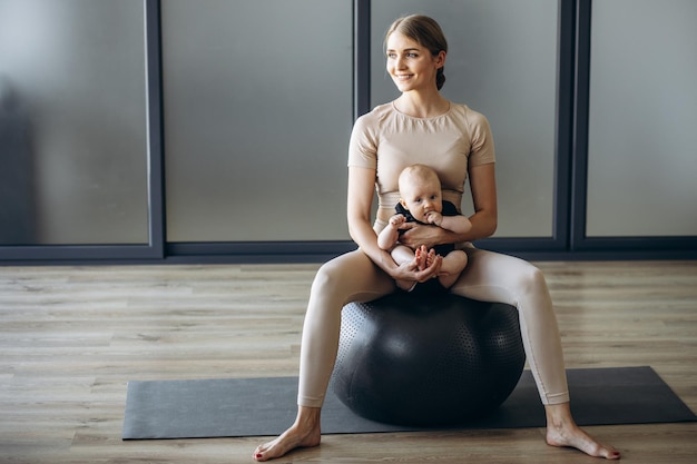 Moeder met babydochter die op yogabal zit