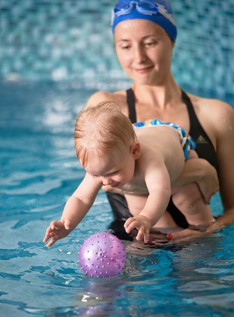 Moeder met babyjongen in zwembadtraining