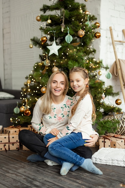 Moeder met dochter dichtbij de kerstboom