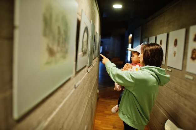 Moeder met dochter die exposities in museumzalen verkent