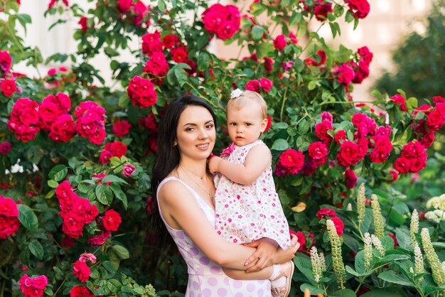 Moeder met dochter op een achtergrond van rode rozen