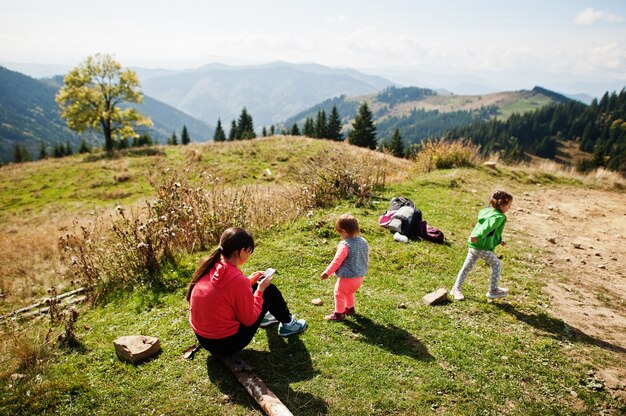 Moeder met dochters die genieten in de bergen. het concept van familiereizen, avontuur en toerisme. lifestyle en wandelen herfstvakanties buiten.