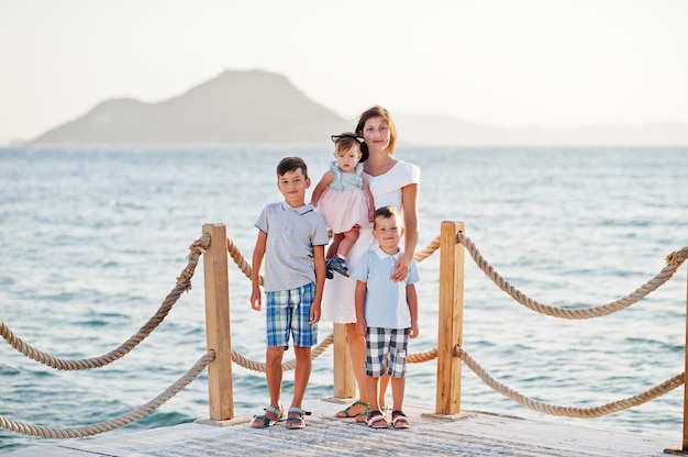 Moeder met drie kinderen in Turkije resort tegen Middellandse Zee staan op de pier.