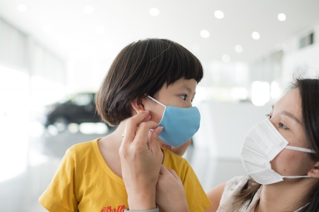 Moeder met gezichtsmasker beschermen voor haar kind