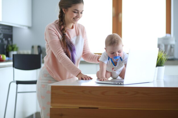 Moeder met haar baby in de lichte keuken thuis