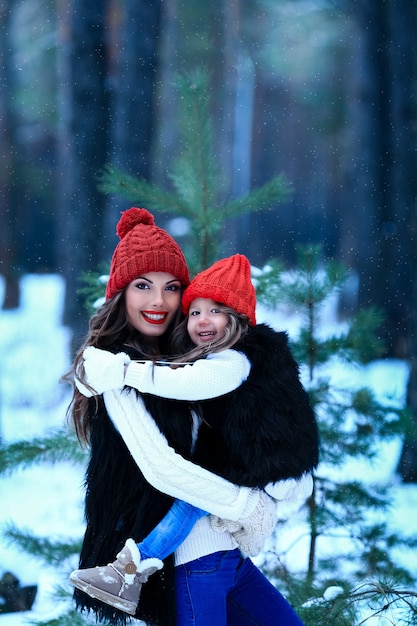 Moeder met haar dochter knuffelt buiten in de winterse natuur