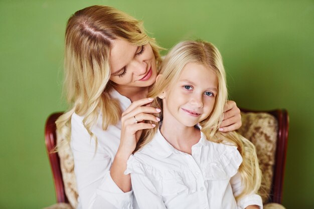 Moeder met haar dochter samen in de studio met groene achtergrond.