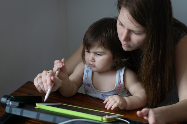 Moeder met haar dochter tekenen op digitale tekentablet