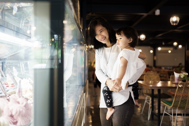 Moeder met haar dochter tijdens het kijken naar een winkel-restaurant-display