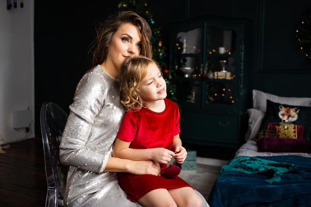 Moeder met haar kinddochter die dichtbij Kerstboom viert