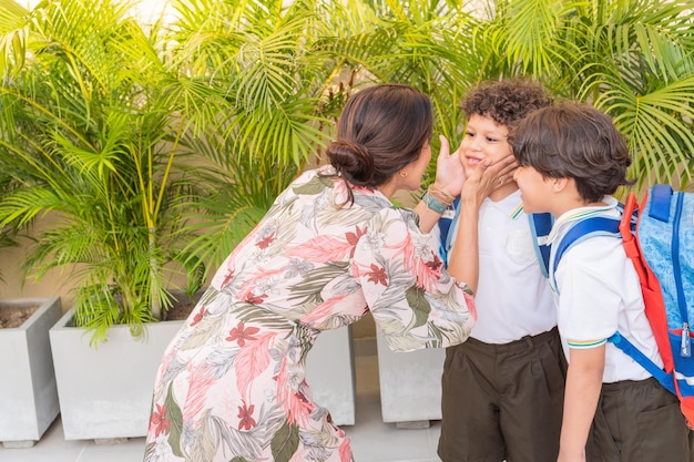 Moeder met haar kinderen die afscheid nemen om naar school te gaan